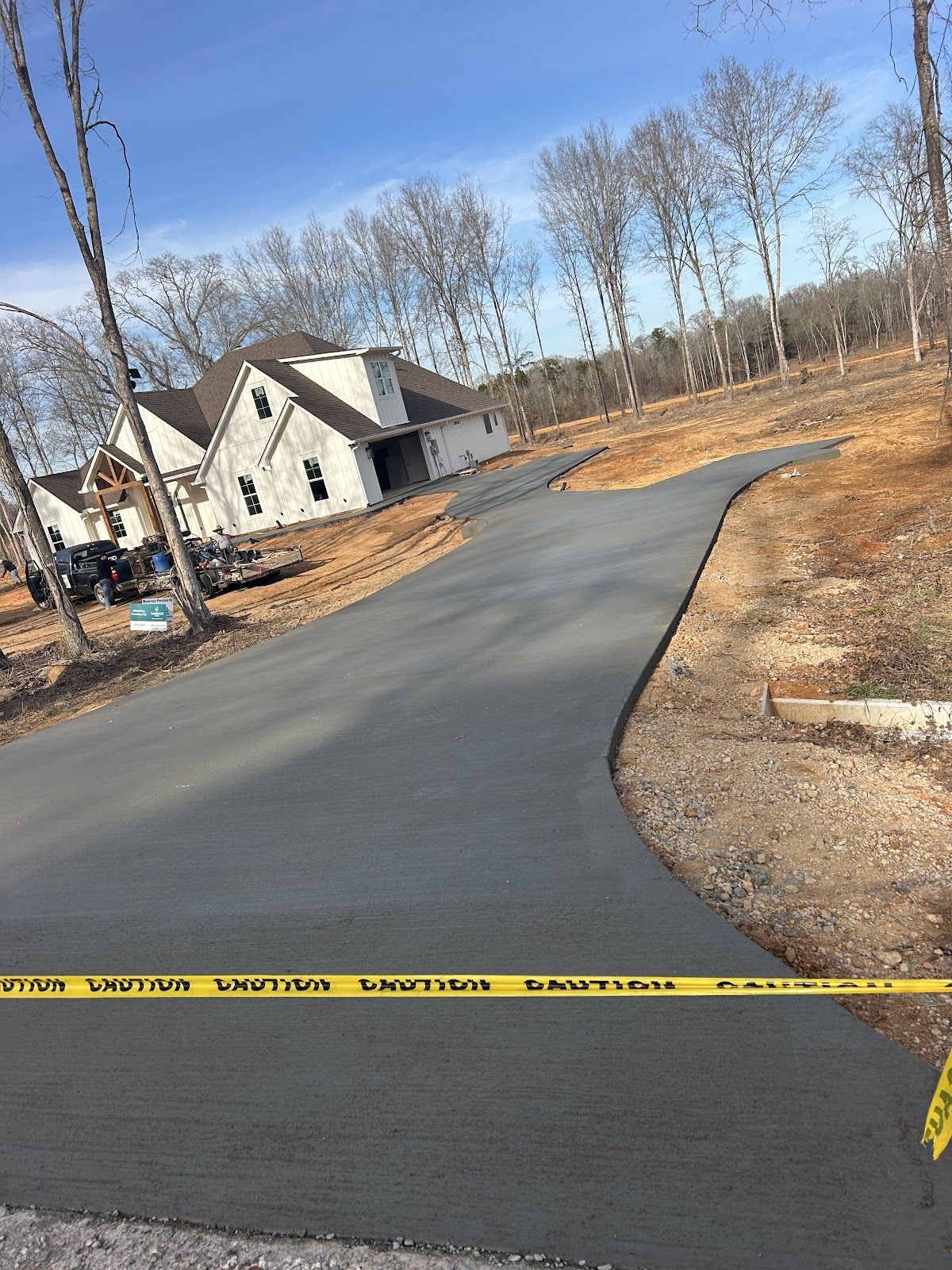 Freshly poured curved concrete driveway at a new home